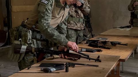 Занятие по огневой подготовке: разборка автомата на столе с учебным оружием